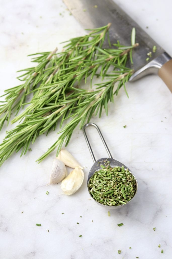 Fresh rosemary chopped in a tablespoon, sprigs of rosemary and fresh garlic