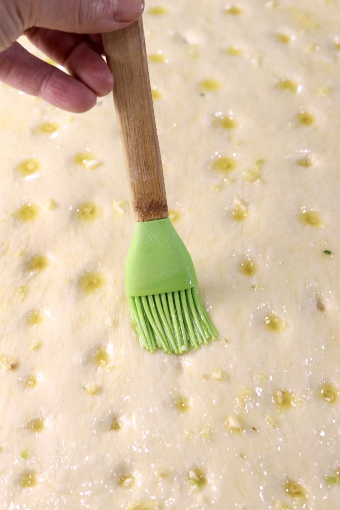 Brushing Focaccia Dough with garlic olive oil