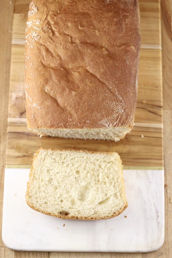 Overhead view loaf of white sandwich bread with end sliced