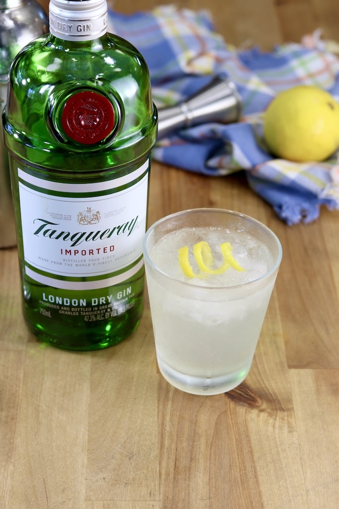 Bottle of Tanqueray Gin with a Gin Sour Cocktail with a lemon twist garnish