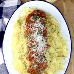 Roasted Tomato Sauce served over spaghetti squash on an oval platter, garnished with grated parmesan and green herbs