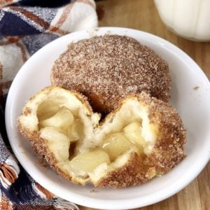Churro Apple Pie Bombs on a saucer, one split in half with apple filling showing
