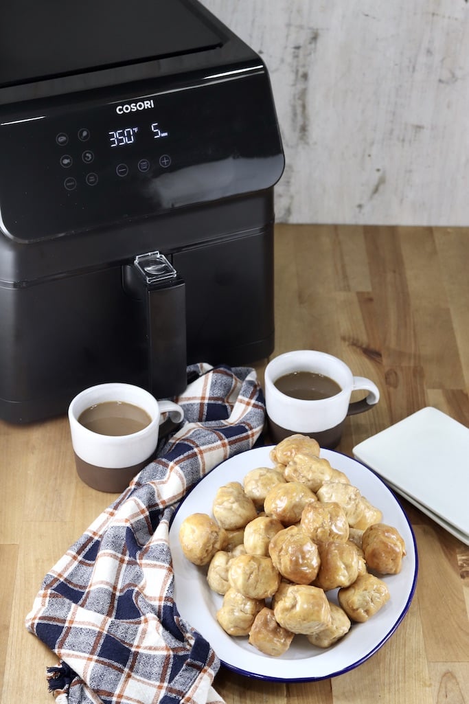 Cosori Air Fryer with 2 cups of coffee, donut holes on a platter