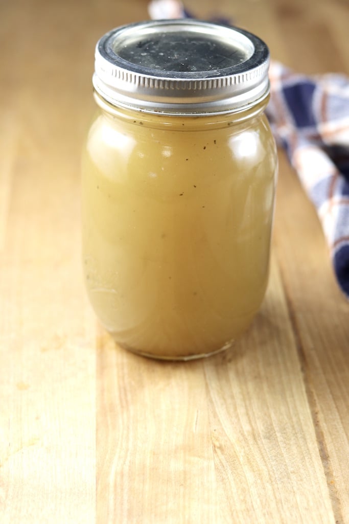 Jar of chicken broth on a butcher block counter