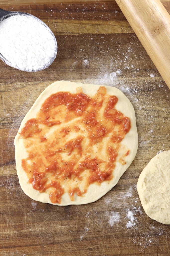 Pizza dough topped with marinara