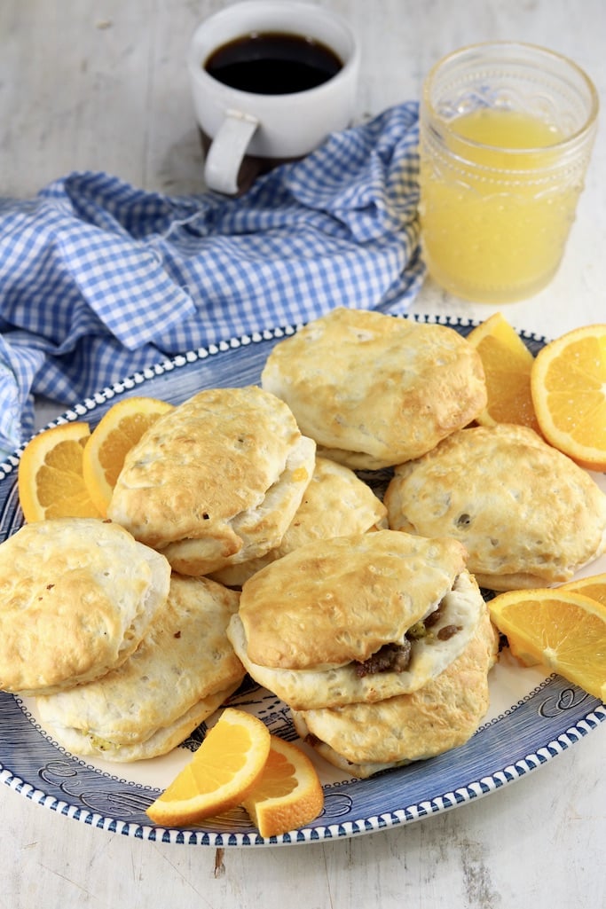 Platter of sausage biscuits with coffee and orange juice