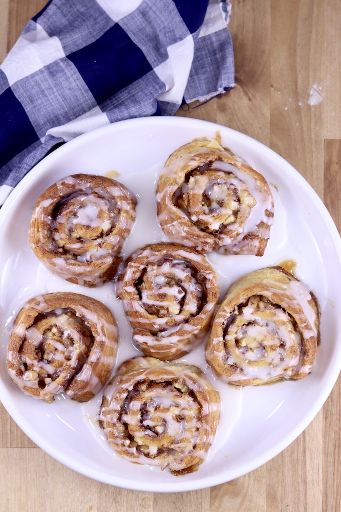 Air Fryer Apple Cinnamon Rolls overhead view on a white plate with blue napkin