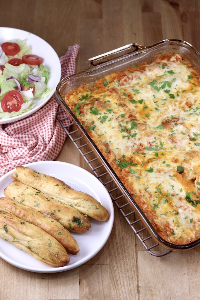 Pan of manicotti, breadsticks and a salad