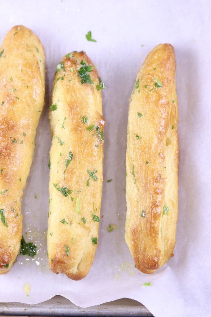 Air Fryer Breadsticks with garlic butter - 3 on a white parchment lined pan