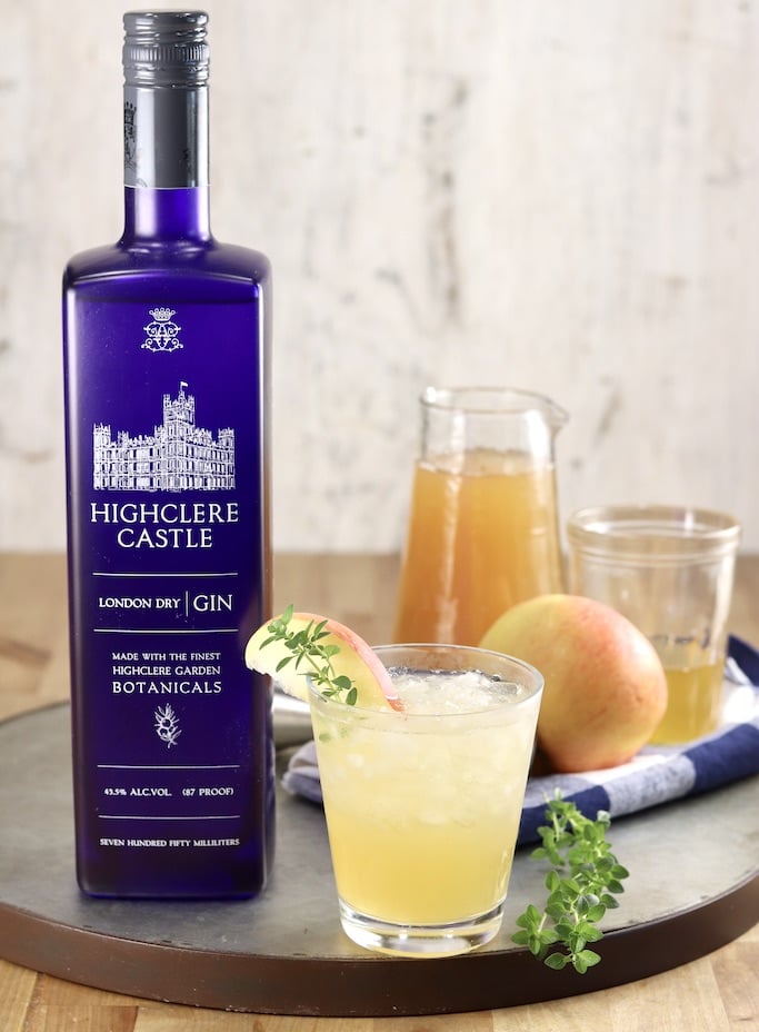 Highclere Castle Gin with apple cider, honey syrup, gin cocktail, whole apple and fresh thyme sprigs