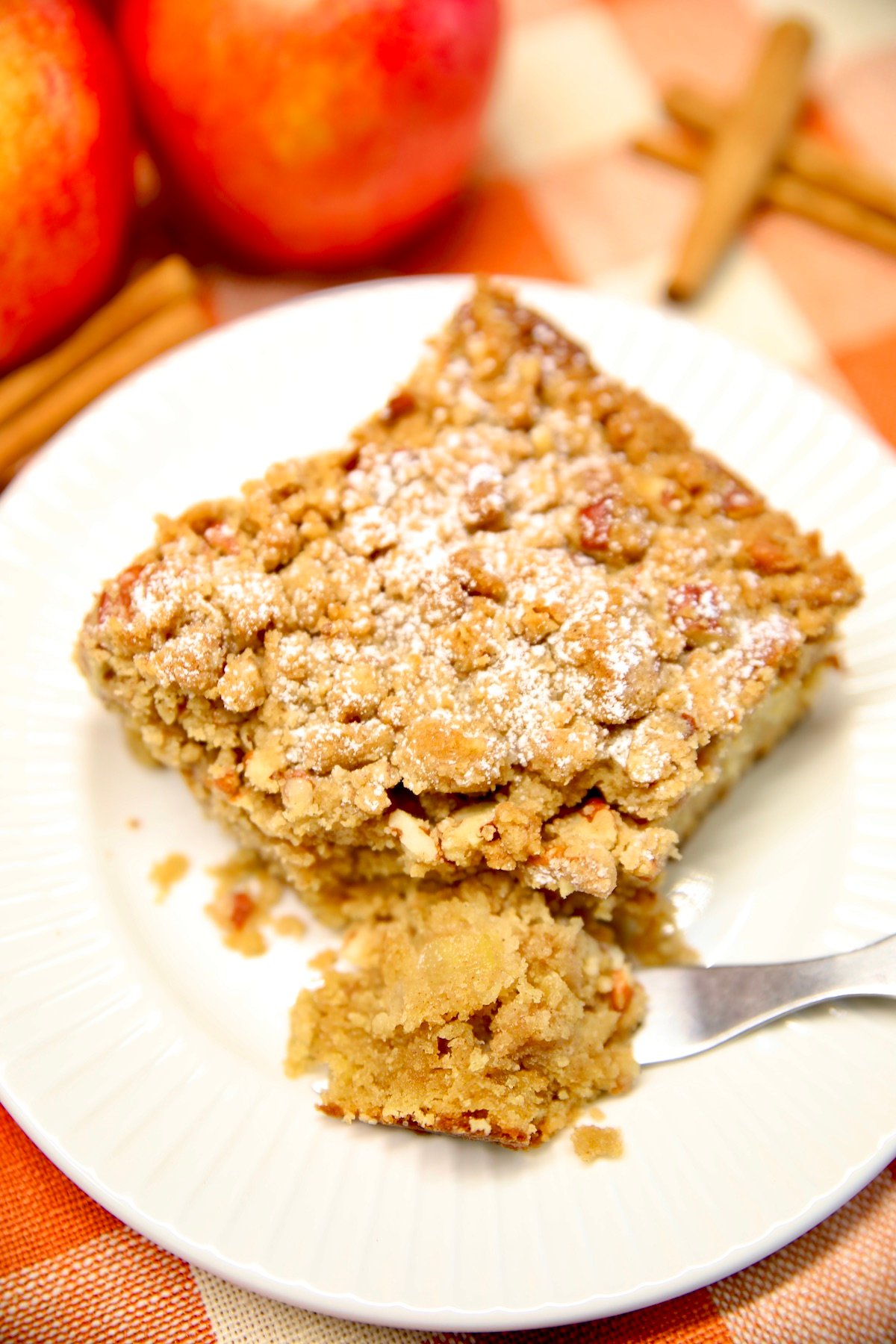 Apple coffee cake on a plate with bite on fork.