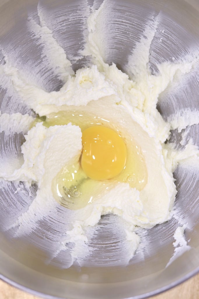 Butter and sugar mixed with an egg added in a mixer bowl