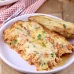 Manicotti on a plate with a breadstick