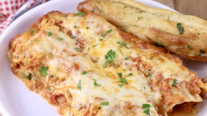 Manicotti on a plate with a breadstick