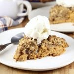 Pumpkin Pecan Crisp topped with ice cream on a white plate with spoon