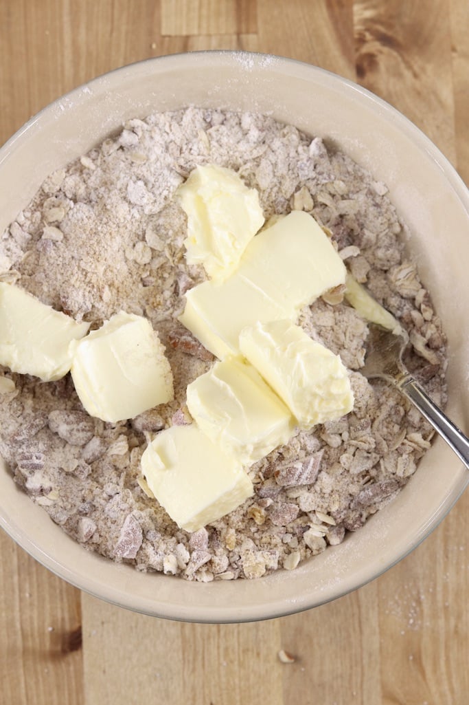 Cubes of butter over brown sugar oat mixture for crisp dessert topping