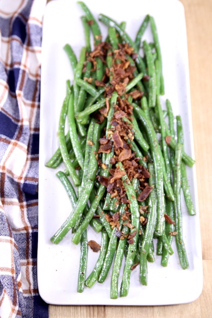 Platter of green beans topped with crispy bacon