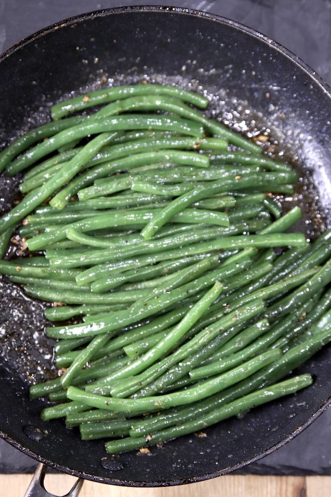 Green beans in a skillet with toasted garlic and brown sugar