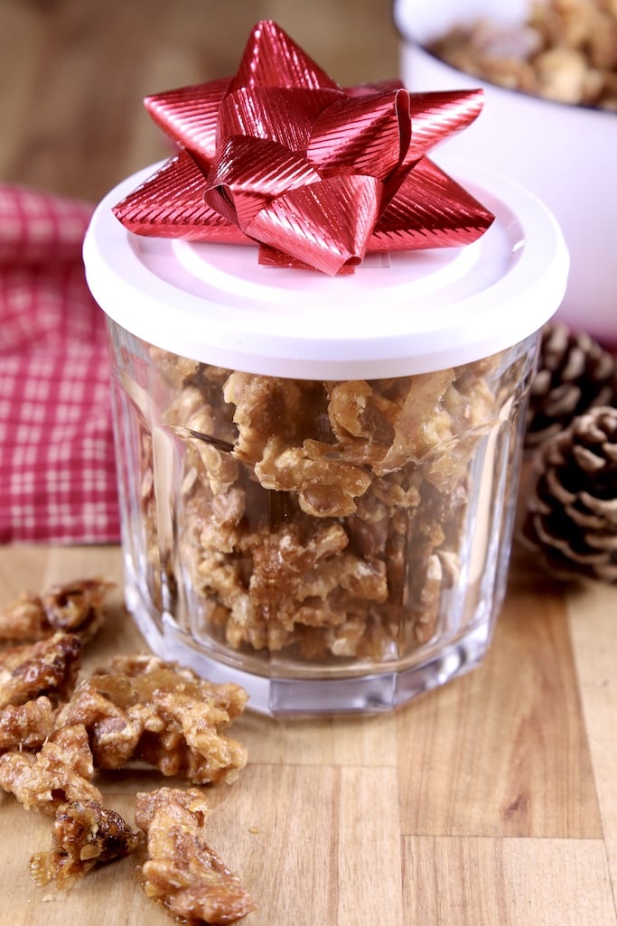 Candied walnuts in a lidded jar with a red bow for a holiday gift