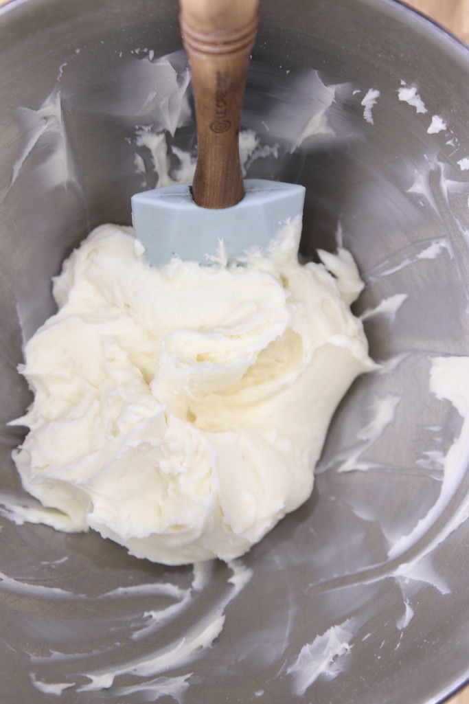 cream cheese icing in a bowl with spatula