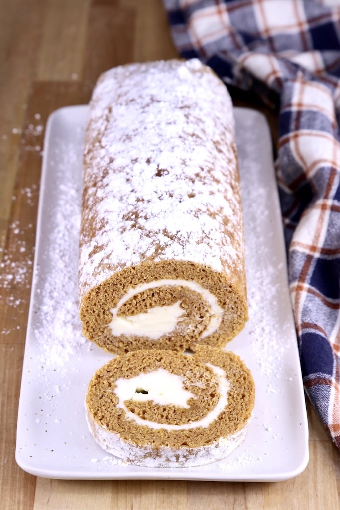 pumpkin roll on a platter with one slice