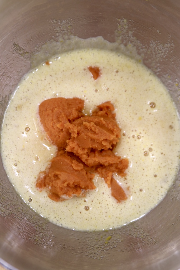 Pureed Pumpkin added to mixing bowl with beaten eggs and sugar