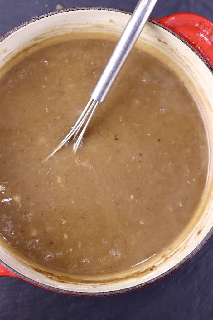 brown gravy in a saucepan with whisk