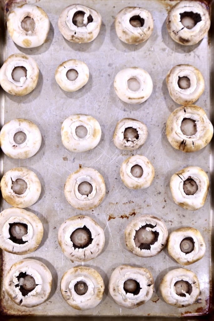 white mushroom caps on a baking sheet