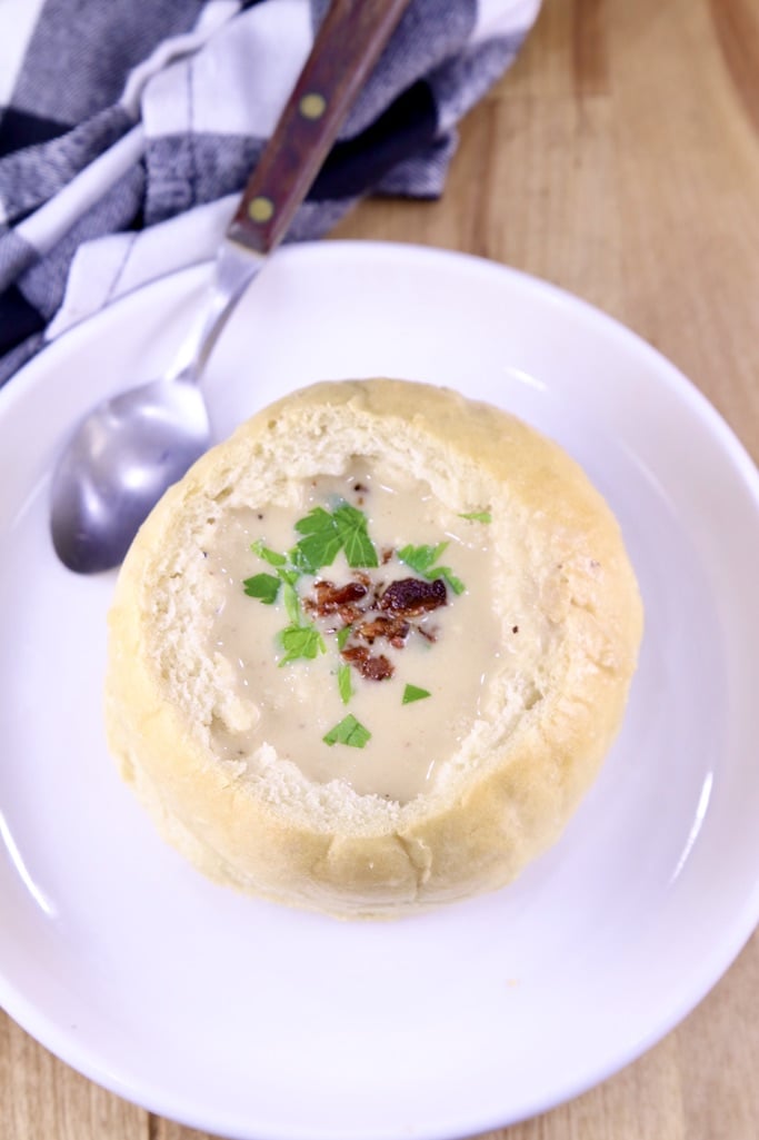 Beer Cheese Soup with bacon and parsley on a saucer with a soup spoon