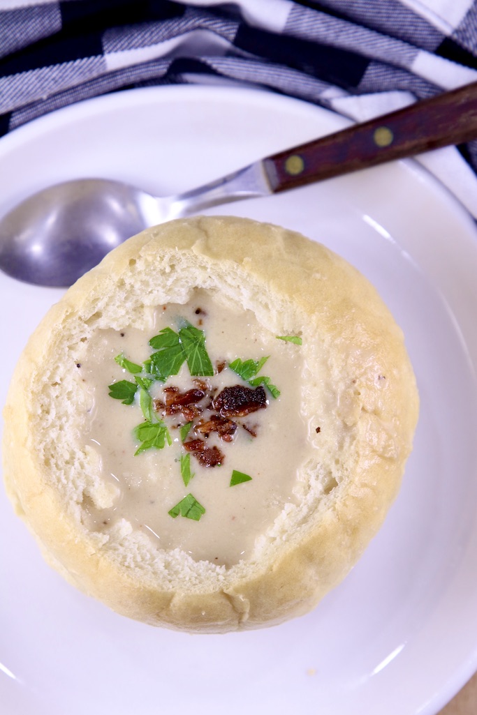 Overhead view of beer cheese soup with bacon in a bread bowl