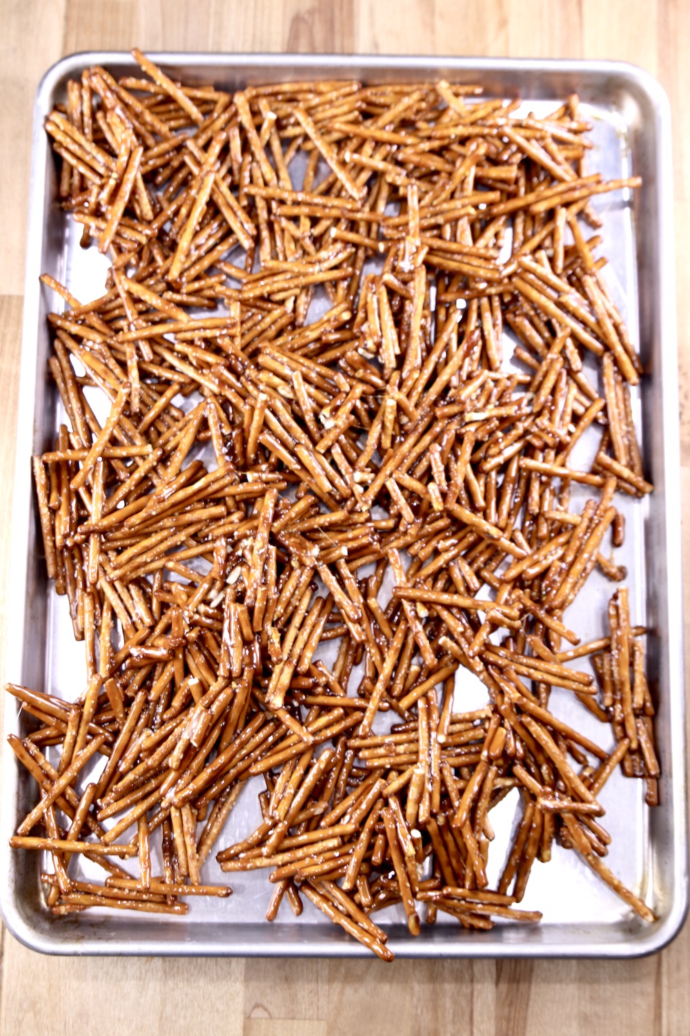 Candied Pretzel sticks spread over a rimmed baking sheet