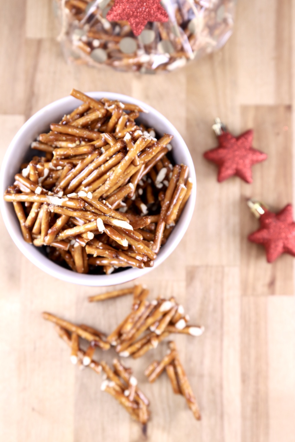 Candied Pretzels in a bowl with a few pieces scattered around. Star ornaments to the side.