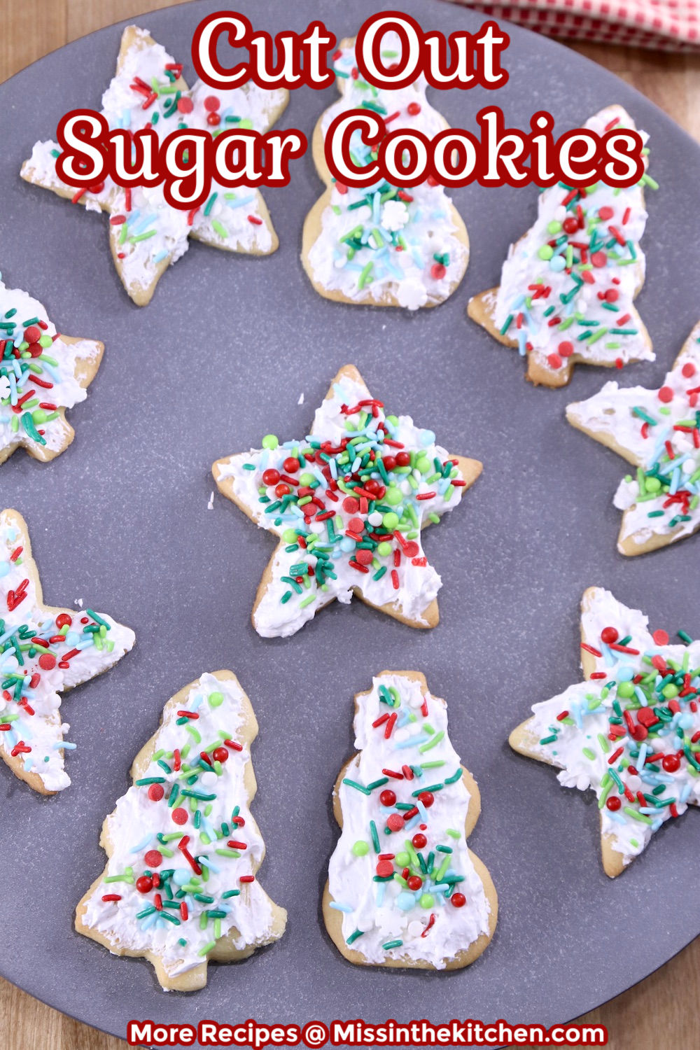 Cut Out Sugar Cookies with icing and sprinkles on a gray plate- text overlay