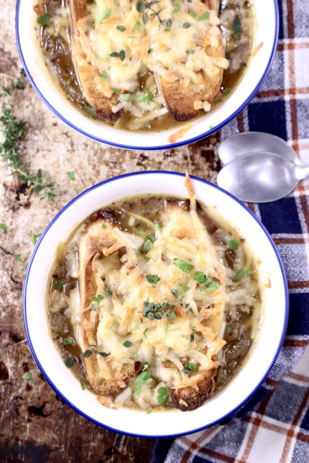 French Onion Soup - 2 bowls topped with melted cheese bread and herbs