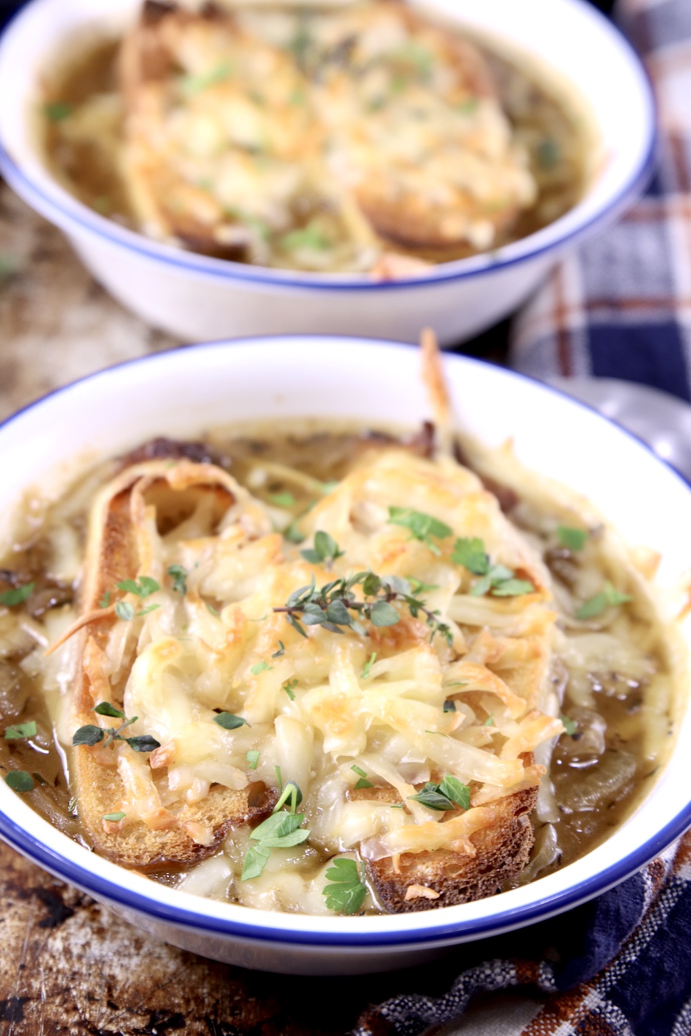 2 bowls of cheese toast topped French Onion Soup