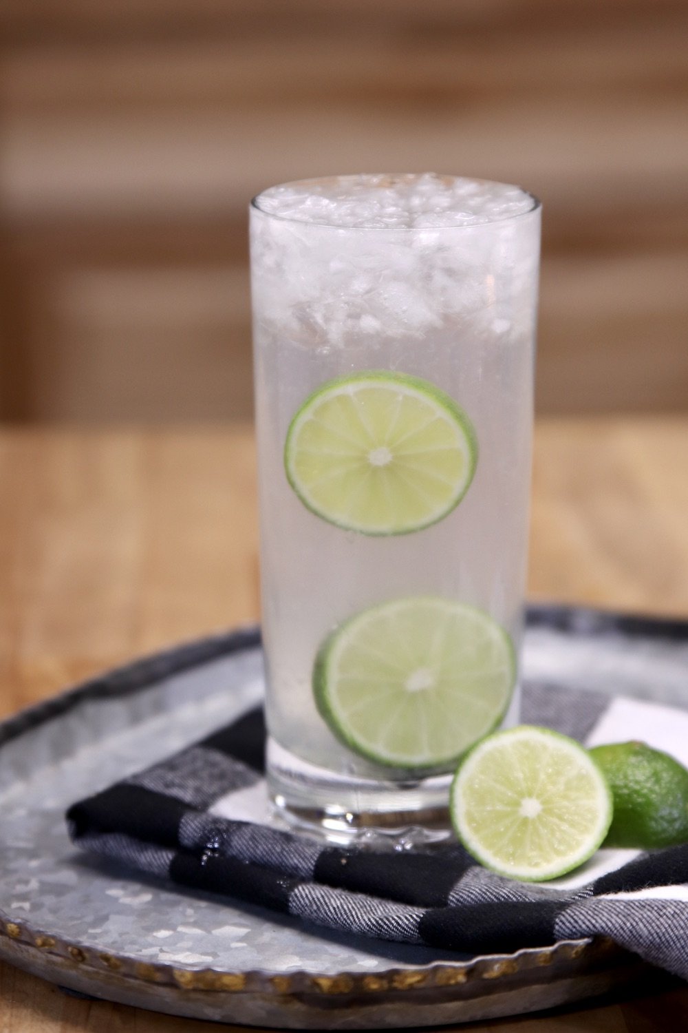 Gin Rickey Cocktail in a tall glass with 2 slices of lime for ganish