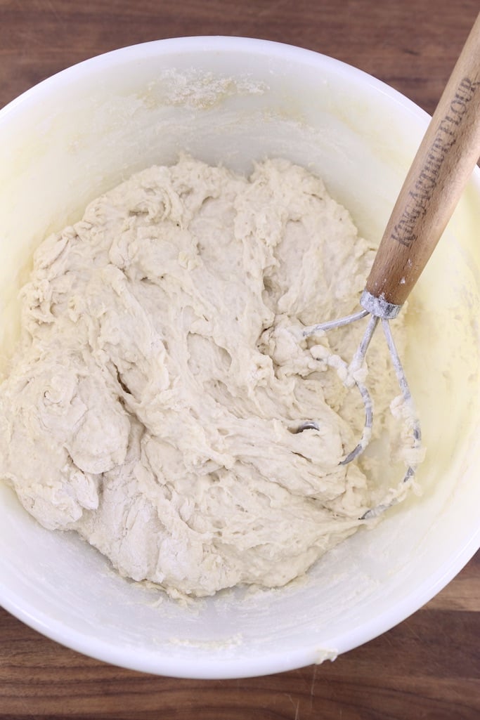 Bread dough in a bowl with a dough whisk