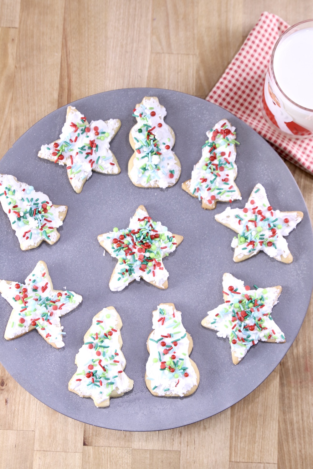 Overhead view of platter of decorated sugar cookies with a glass of milk