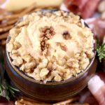 Bacon beer cheese dip with walnut garnish in a bowl