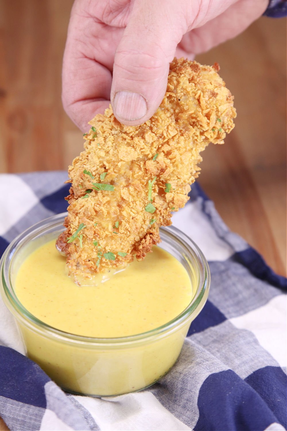 chicken tender dipping in honey mustard sauce