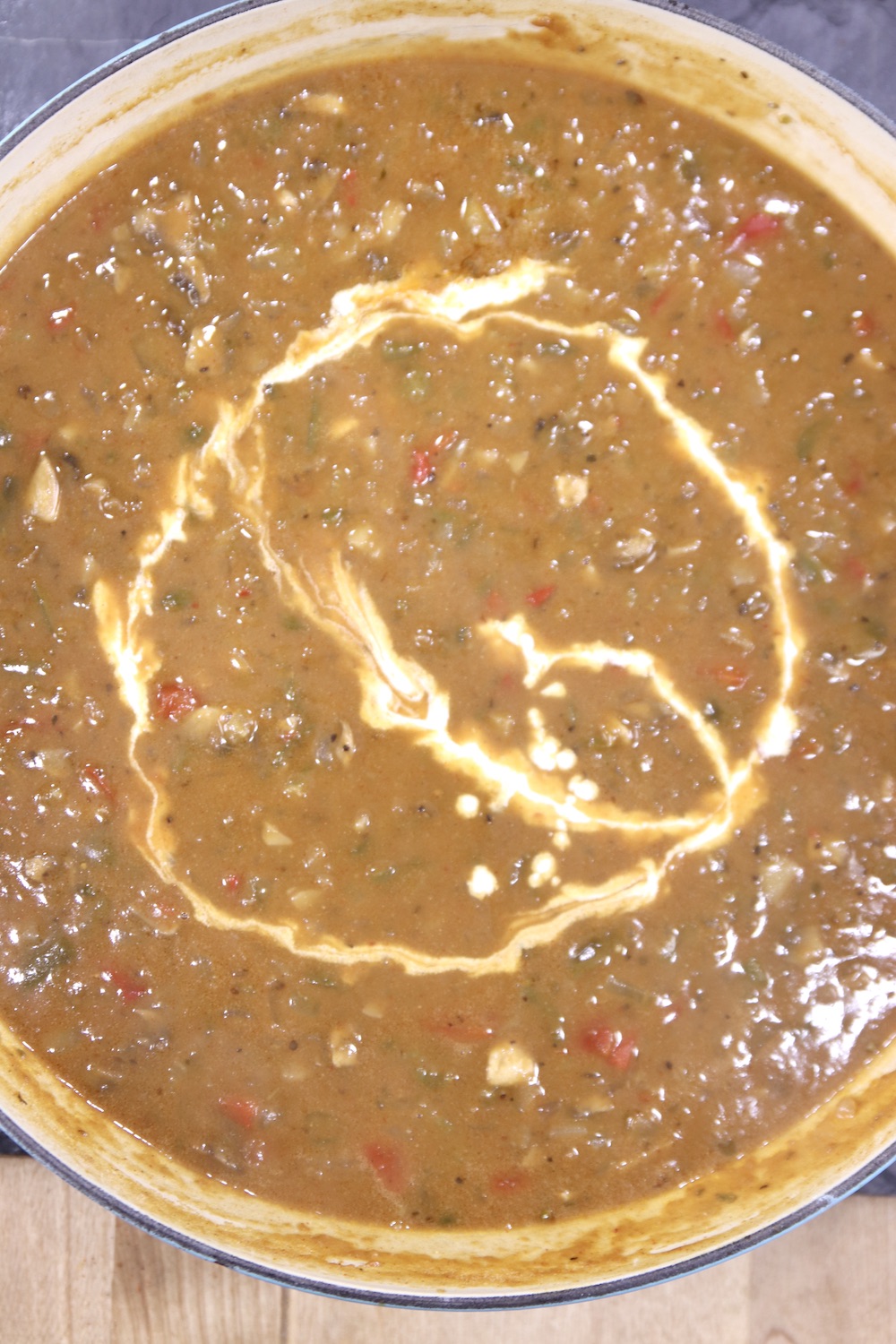 Crawfish pie filling with drizzle of cream in pan