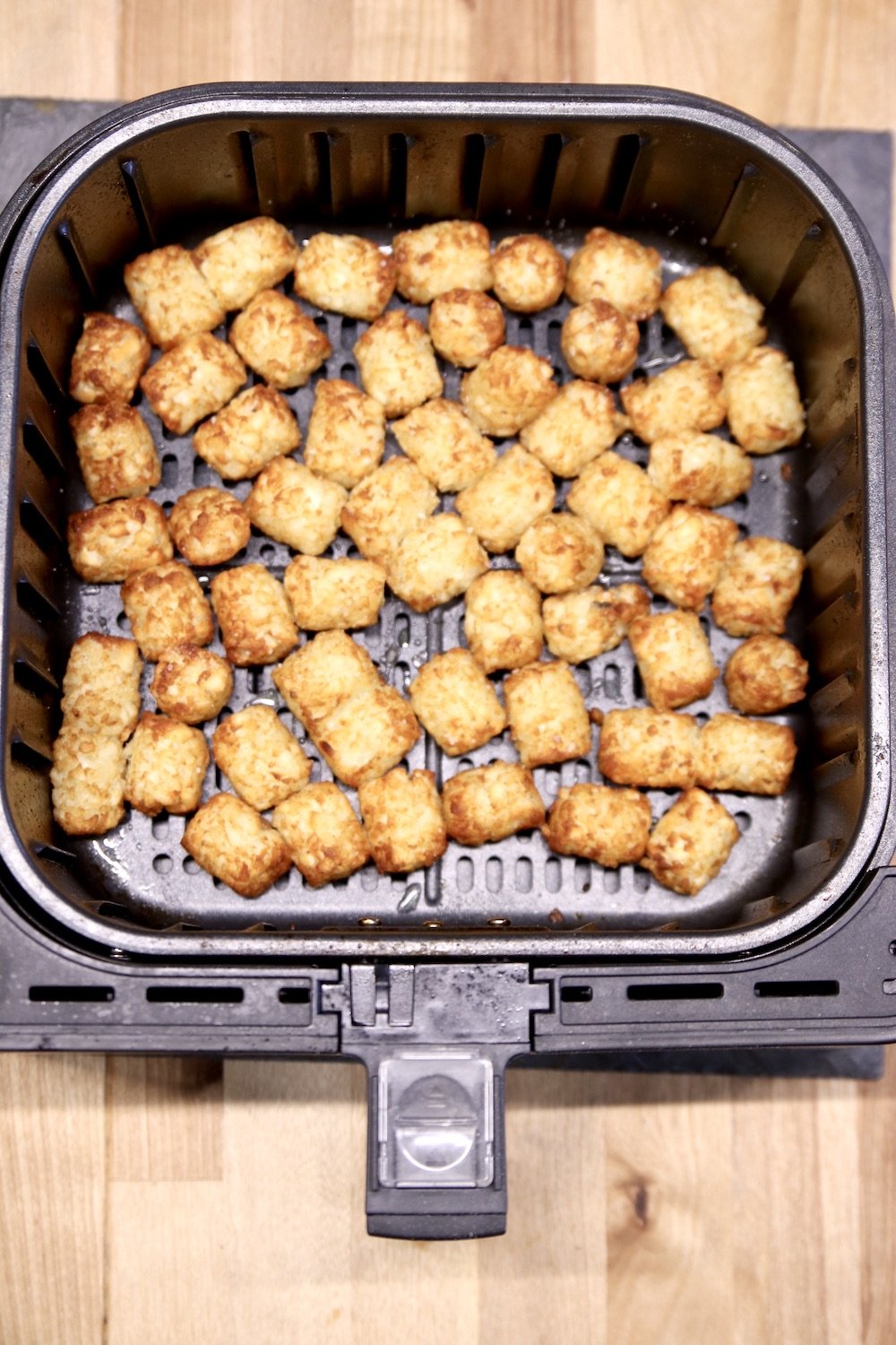 Air fryer basket with browned tater tots