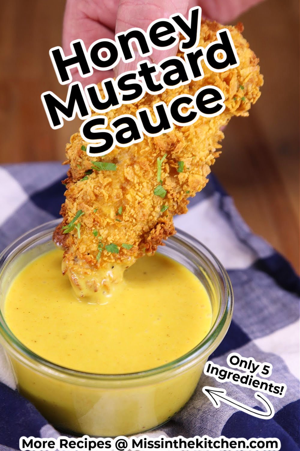chicken strip dipping in honey mustard sauce -text overlay
