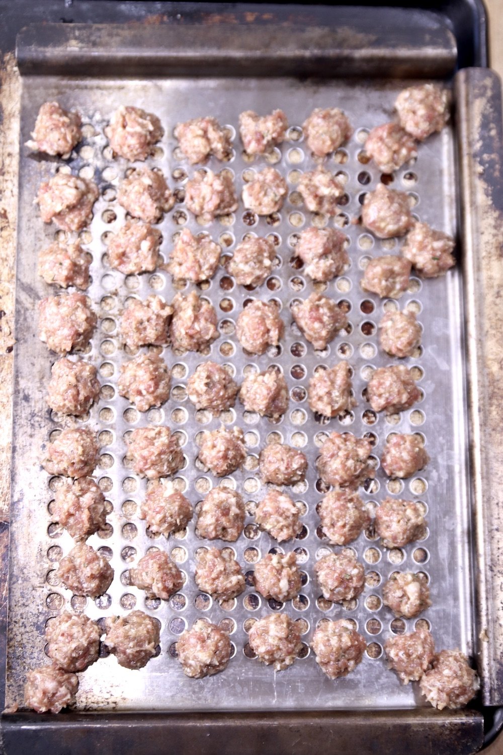 grill pan of raw meatballs