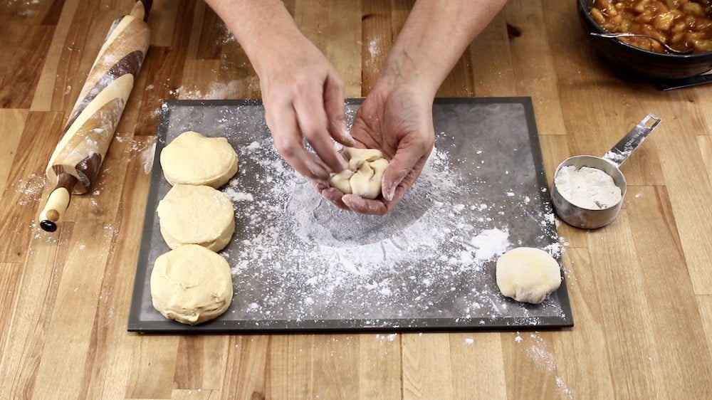 forming biscuit dough peach pie bombs