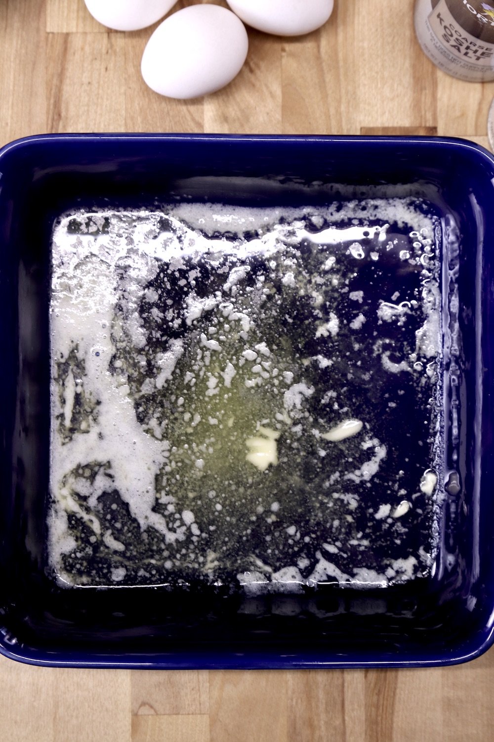 melted butter in a blue square baking dish