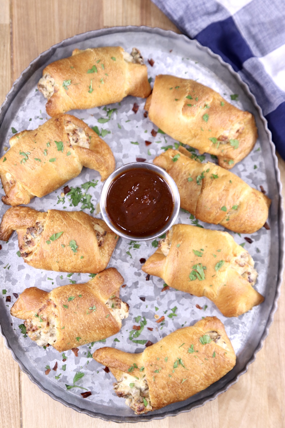 Platter of sausage cream cheese crescents with bbq sauce for dipping