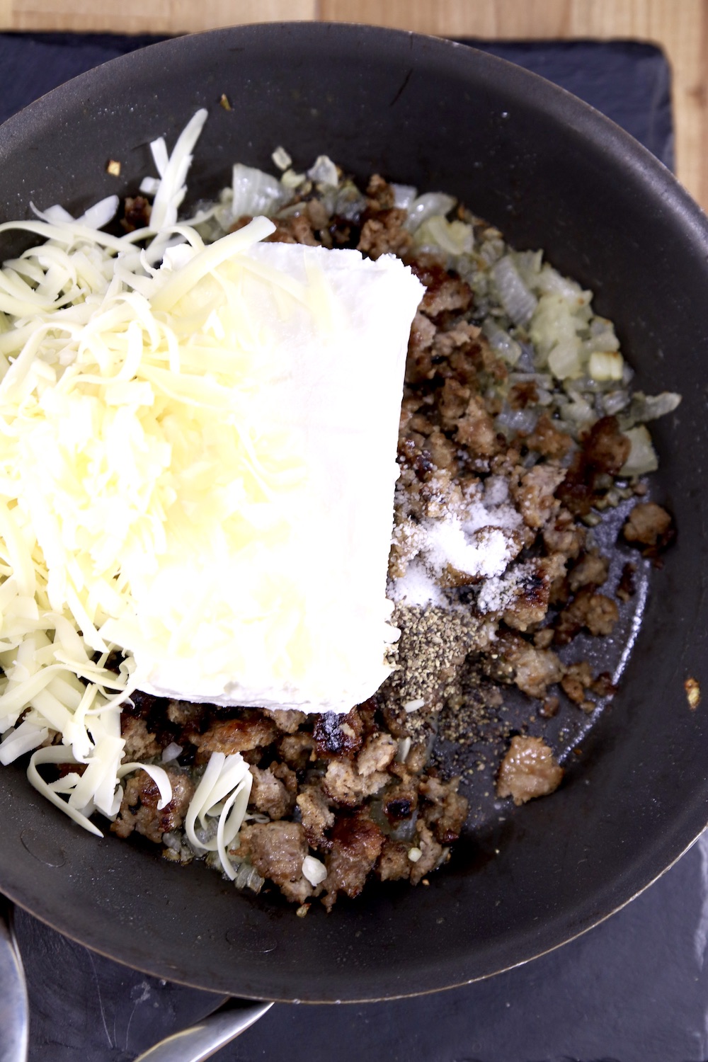 skillet with cream cheese, shredded cheese and sausage