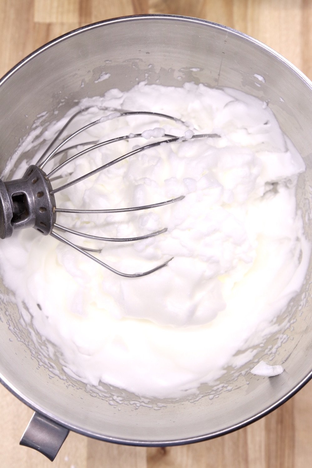 whipped egg whites in a mixer bowl with wire whisk attachment