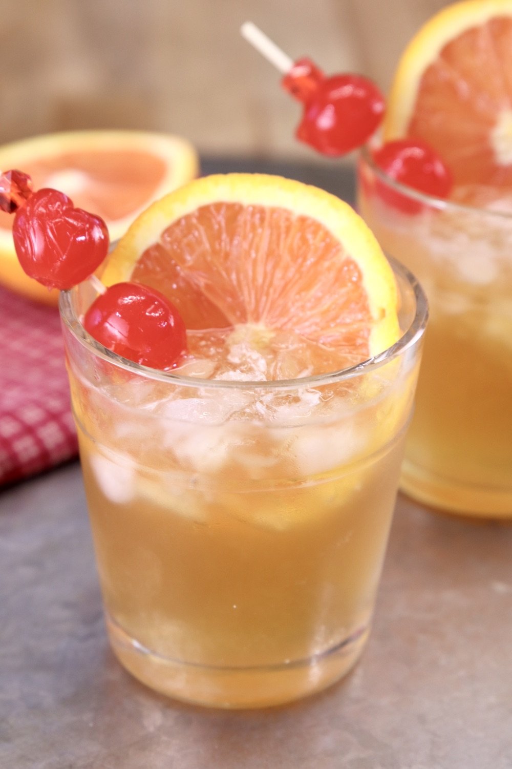Amaretto Sour Cocktail on a platter with orange slice and cherries